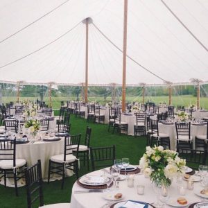 Expansive event tent setup on a scenic landscape, featuring multiple connected tents for large-scale gatherings and outdoor weddings.