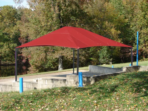 Playground area protected by a red square shade sail.