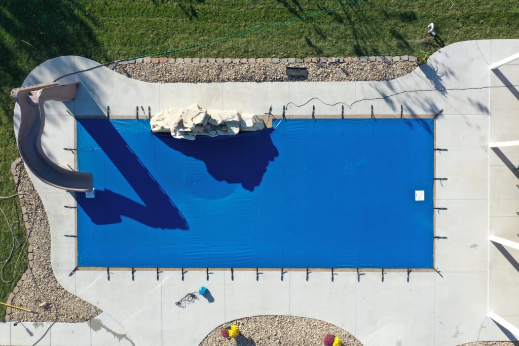 Anchor Industries pool safety cover protecting children and pets around backyard pool.