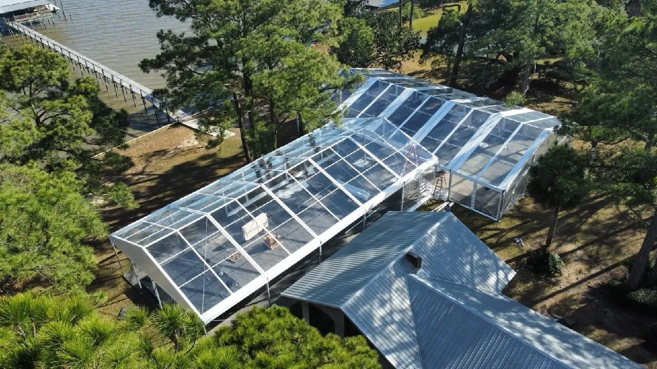 Aerial view of a clear-top structure built among trees with modern design.