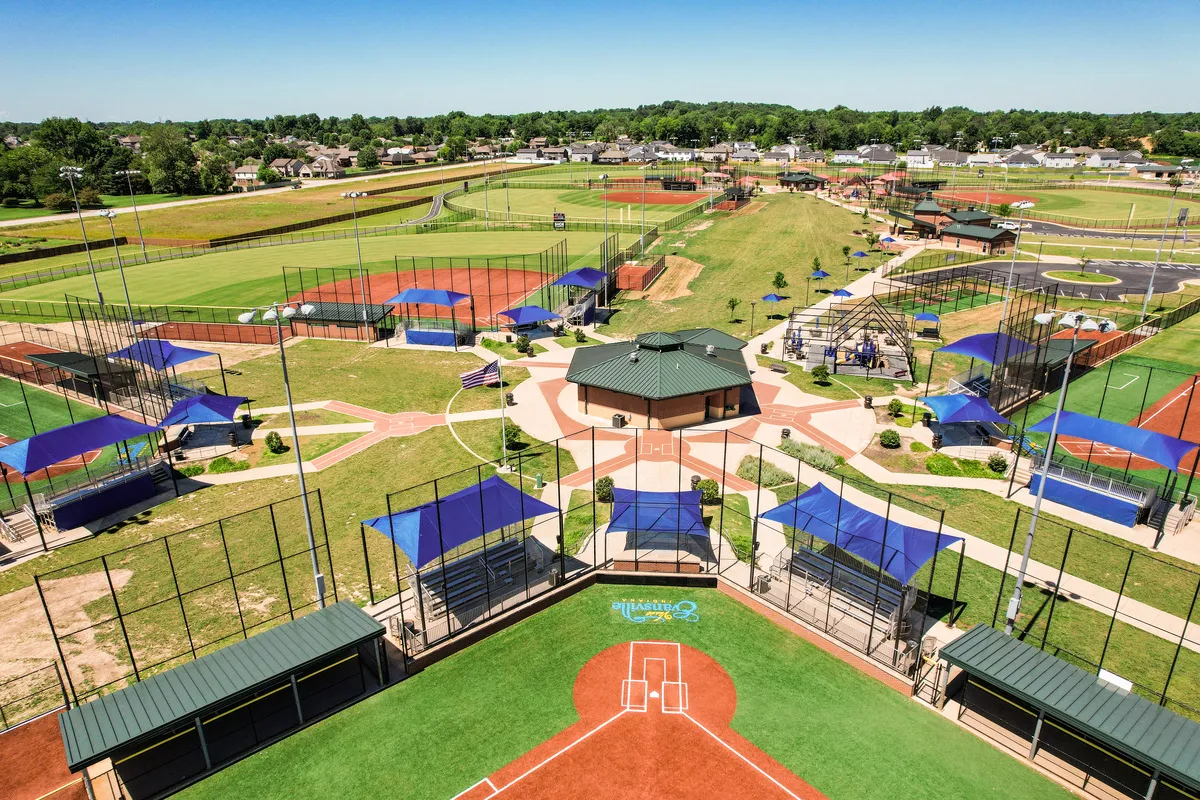 Aerial view of a sports complex featuring baseball fields and covered seating.
