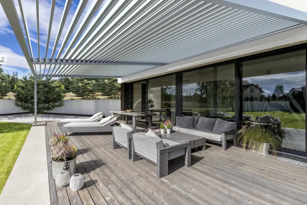 Sleek outdoor patio with gray aluminum pergola and minimalist furniture.