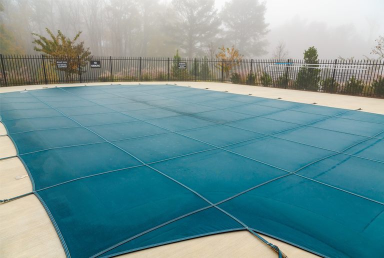 Custom pool cover designed by Anchor Industries to fit unique freeform swimming pool shape.