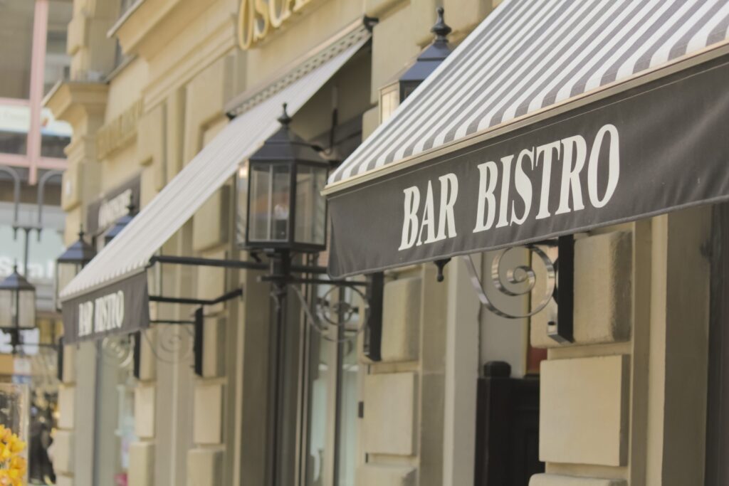Black awning with “BAR BISTRO” lettering on a city building.