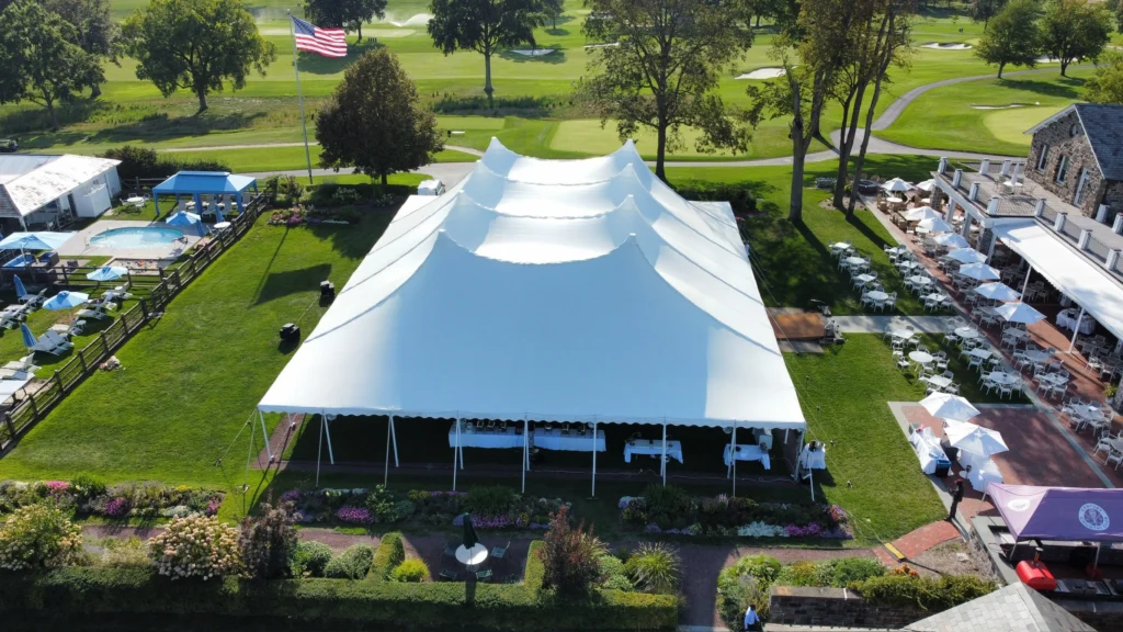 Large white high peak wedding tent by Anchor Industries on golf course