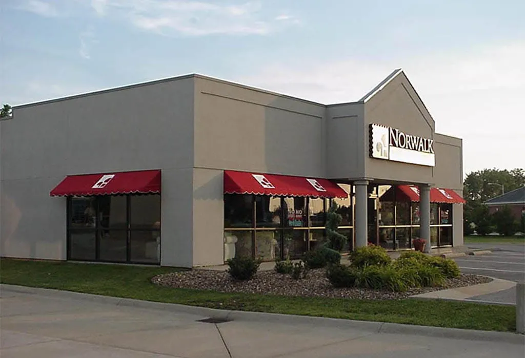 Commercial building with red and black window awnings.