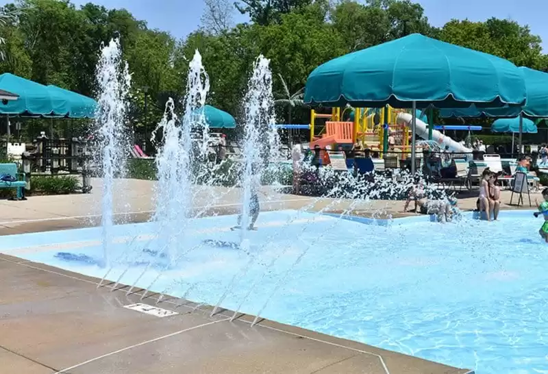 Green pool shade umbrella by Anchor Industries near splash pad