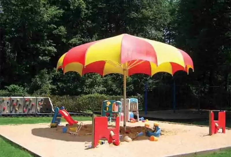 Anchor Industries yellow and red shade umbrella at children’s play area