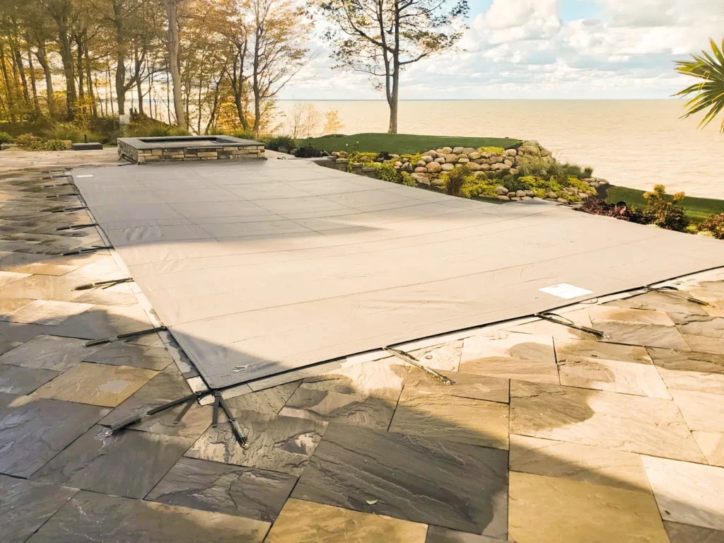 Navy pool cover on custom-shaped pool – Dark navy safety cover installed on a large custom-shaped pool.
