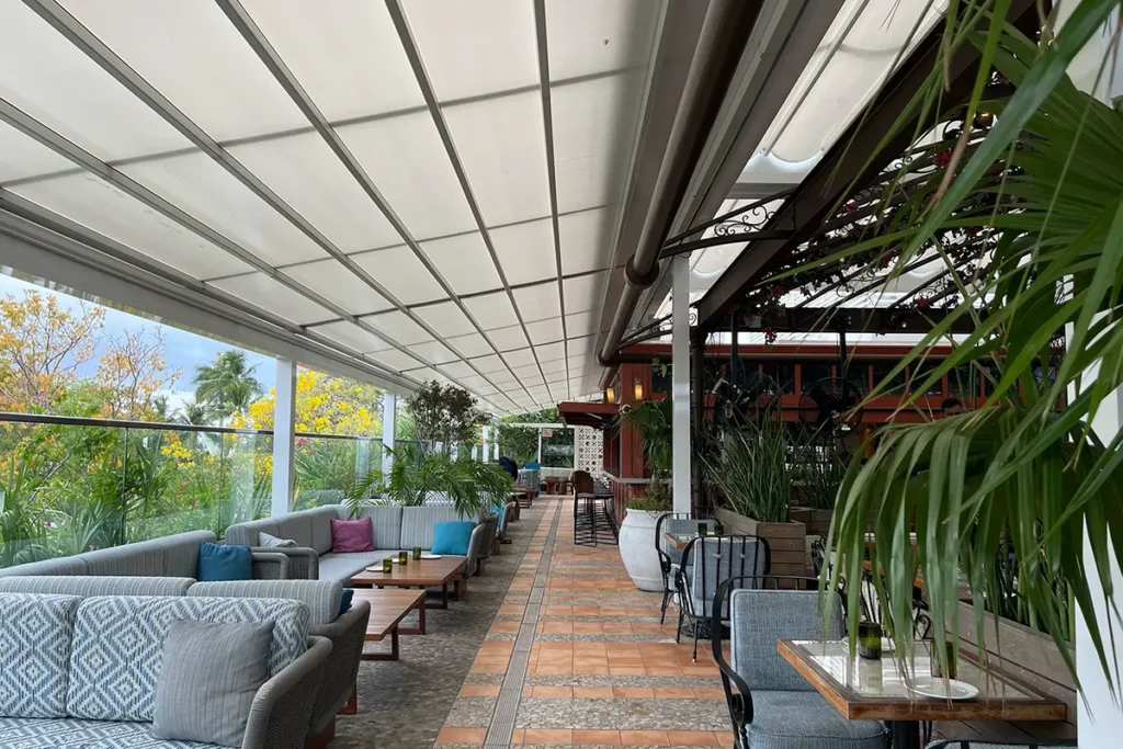 Retractable fabric pergola shading an outdoor restaurant terrace.