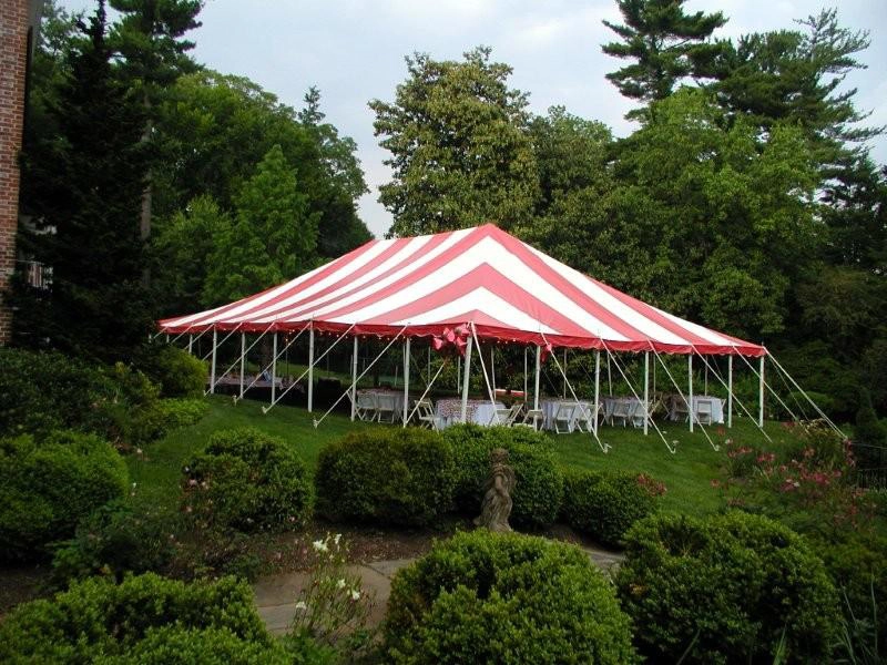 Red and white striped Anchor Industries pole tent at outdoor venue
