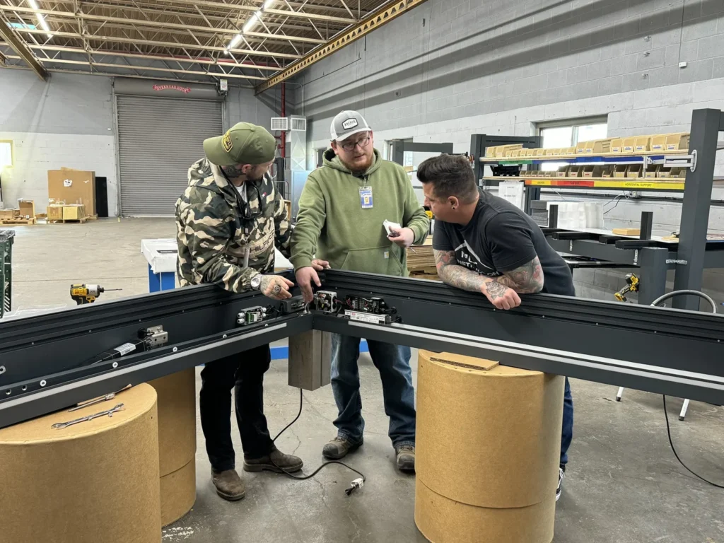 Group of people assembling pergola components in a workshop.