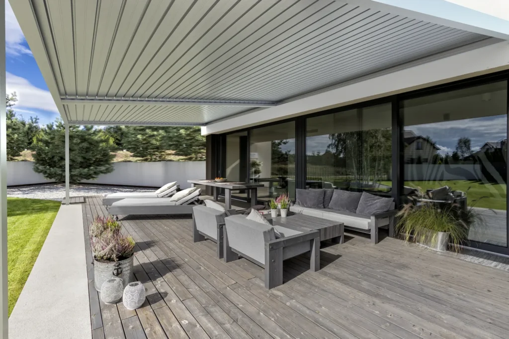 Patio with louvered pergola providing shade for outdoor furniture.