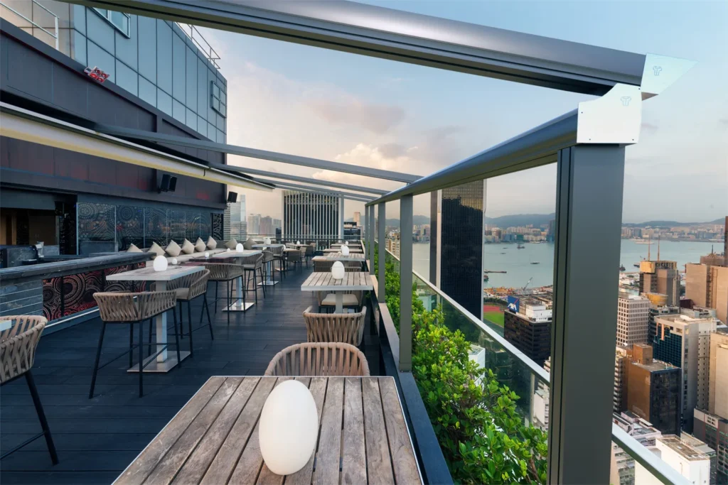 Pergostar Plus retractable pergola system installed on a high-rise rooftop restaurant terrace with panoramic city views