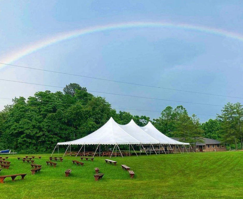 White high peak wedding tent by Anchor Industries with rainbow in background
