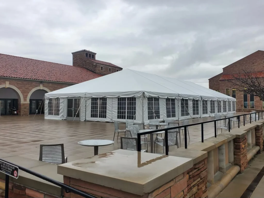 Building rooftop with white awning covering outdoor seating.