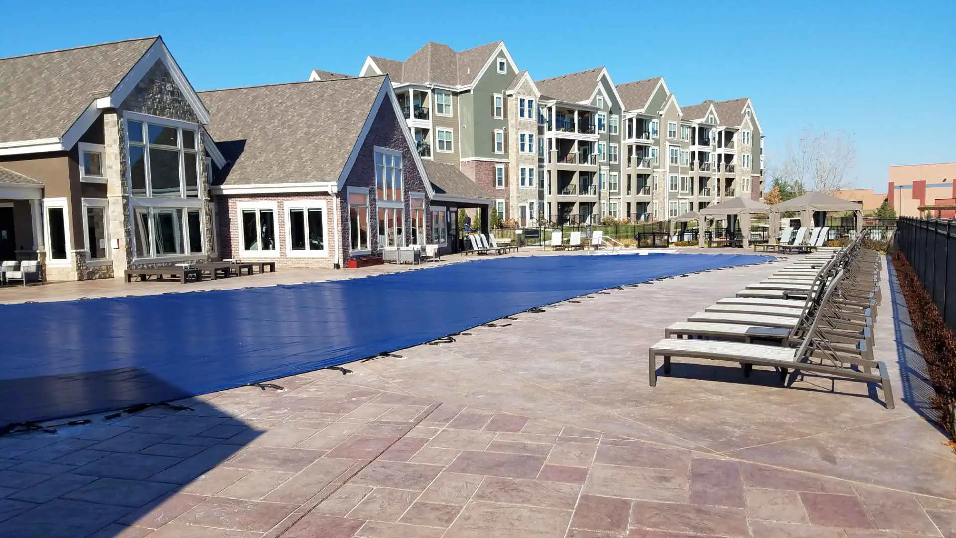 Resort pool with blue cover – large pool at luxury residence covered with bright blue safety cover.