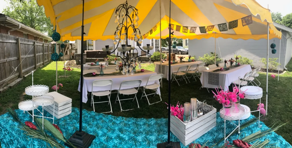 Anchor Industries yellow and white pole tent with tables and chairs inside