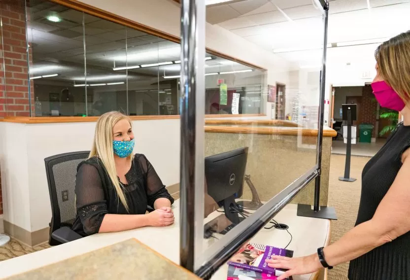 Employee workstation with Anchor Industries clear safety barrier