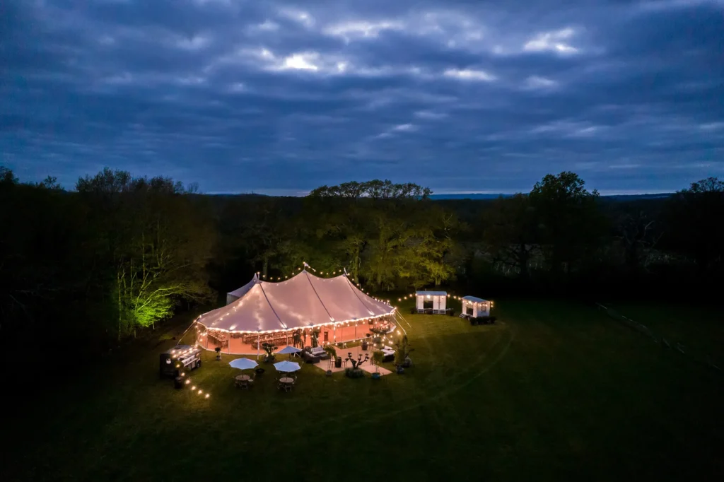 Glowing event tent illuminated at night in an open field.