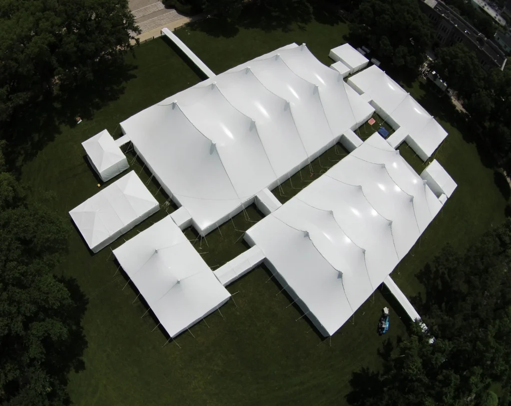 Aerial view of multiple connected white tents forming a large complex.