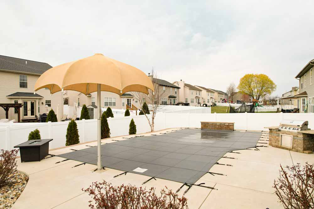 Large tan patio umbrella shading a paved outdoor area.