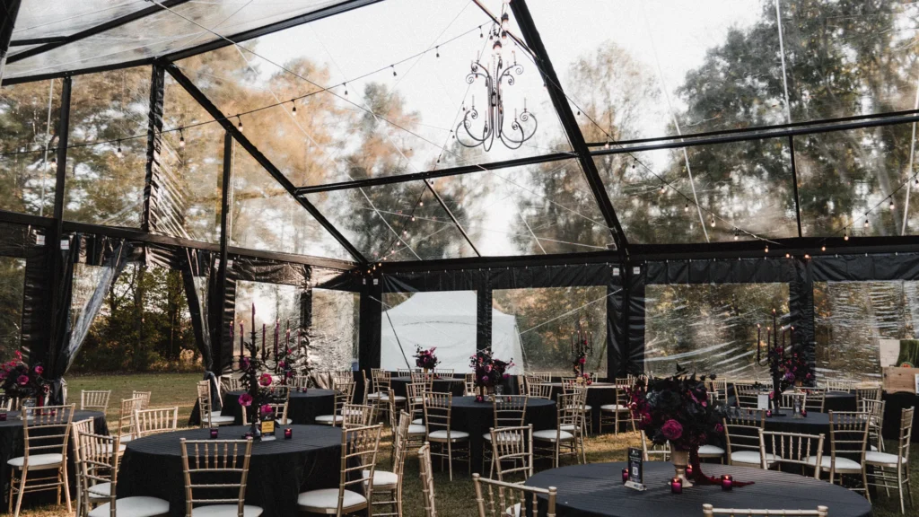 Interior view of a high peak pole tent featuring a dance floor and banquet seating