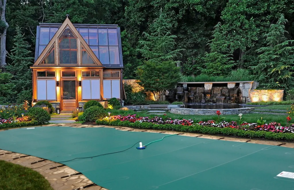 A custom safety cover installed over a clean backyard fiberglass pool.