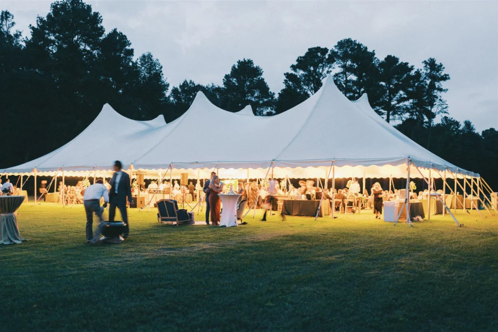 Exterior of a commercial tension tent set up on grass for a high-end corporate cocktail reception.
