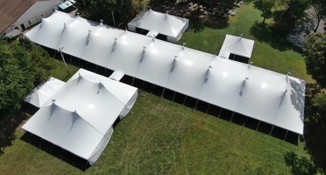 Rental company replacing a worn tent top with new fabric from Anchor Industries before the next event season.