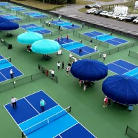 An outdoor pickleball court cooled by a durable Anchor shade structure to protect players from UV rays.